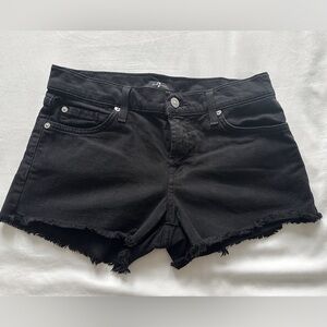 7 For All Mankind low-rise black jean shorts with ruffled hem.
